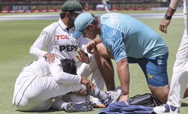 Pakistan's Saim Ayub, left, injures his ankle during the second test match between South Africa and Pakistan in Cape Town, South Africa, Friday, Jan. 3, 2025. (AP Photo/Halden Krog)