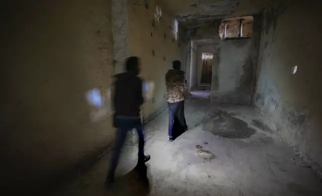 FILE - People walk through a corridor of Syria's infamous Saydnaya military prison, just north of Damascus, Syria, on Dec. 9, 2024. (AP Photo/Hussein Malla, File)