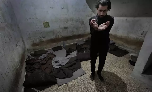 Abdullah Zahra demonstrates how he was tortured in a cell at Branch 215, a detention facility run by military intelligence during Bashar Assad's regime, in Damascus, Syria, on Tuesday, Dec. 17, 2024. (AP Photo/Hussein Malla)