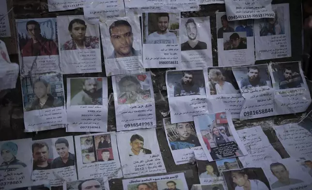 FILE - Photos of people reported to be missing after being detained by former Syrian President Bashar Assad's army, or pro-government militias, are seen in Damascus, Syria, on Dec. 22, 2024. (AP Photo/Leo Correa, File)