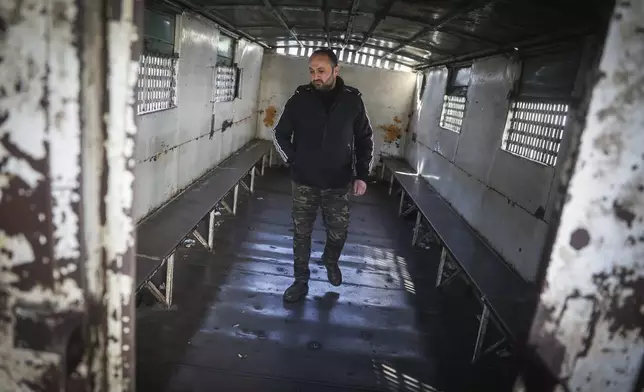 Mahmoud Abdulbaki stands in one of the trucks used during the time he was in the Military Police prison in Damascus, Syria, on Dec. 15, 2024. (AP Photo/Ghaith Alsayed)