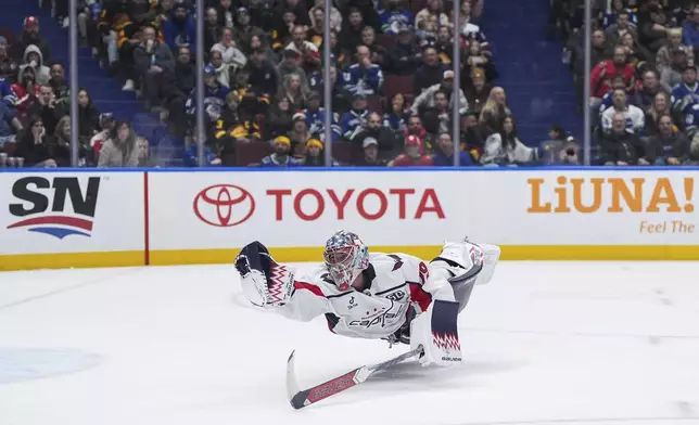 Washington Capitals goalie Charlie Lindgren dives to make a glove save after being caught out of position while skating to the bench for the extra attacker during the third period of an NHL hockey game in Vancouver, British Columbia, on Saturday, Jan. 25, 2025. (Darryl Dyck/The Canadian Press via AP)