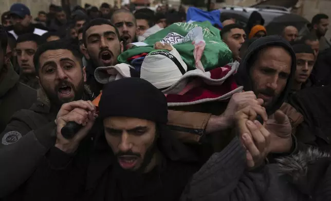 FILE - Mourners carry the body of Palestinian Zein Atatrah, 18, wrapped with a Hamas flag during his funeral in Ya'bad, West Bank, on Dec. 27, 2024. (AP Photo/Nasser Nasser, File)