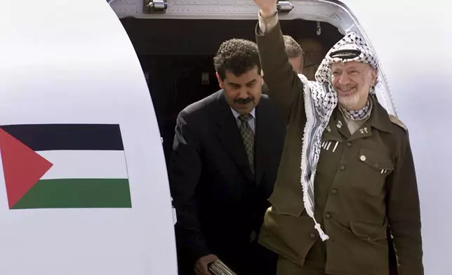 FILE - Palestinian leader Yasser Arafat waves to supporters shortly after his arrival at Gaza International Airport on July 26, 2000. The Camp David summit, in pursuit of a Middle East peace settlement, collapsed on July 25 without an agreement between Israel and the Palestinians. (AP Photo/Lefteris Pitarakis, File)