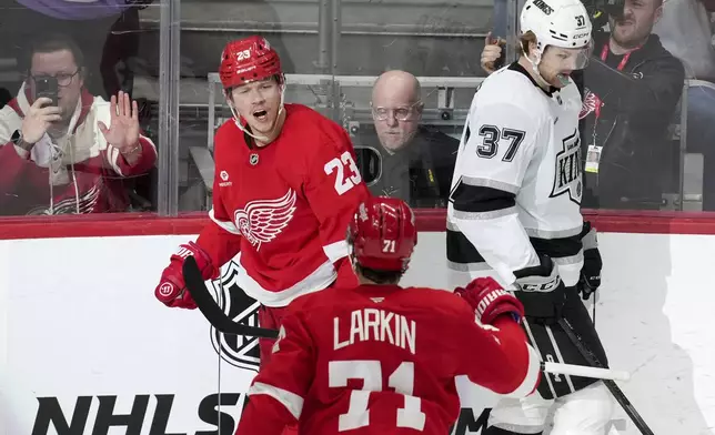 Detroit Red Wings left wing Lucas Raymond (23) celebrates his goal with Dylan Larkin (71) as Los Angeles Kings left wing Warren Foegele (37) skates to the bench in the first period of an NHL hockey game Monday, Jan. 27, 2025, in Detroit. (AP Photo/Paul Sancya)
