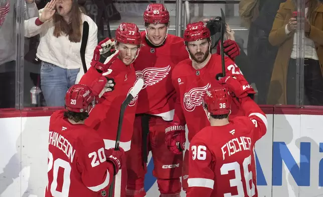 Detroit Red Wings left wing Elmer Soderblom (85) celebrates his goal with Albert Johansson (20), Simon Edvinsson (77), Michael Rasmussen (27) and Christian Fischer (36) against the Los Angeles Kings in the second period of an NHL hockey game Monday, Jan. 27, 2025, in Detroit. (AP Photo/Paul Sancya)