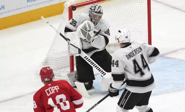 Los Angeles Kings goaltender Darcy Kuemper (35) blocks a Detroit Red Wings center Andrew Copp (18) shot as defenseman Mikey Anderson (44) looks on in the first period of an NHL hockey game Monday, Jan. 27, 2025, in Detroit. (AP Photo/Paul Sancya)