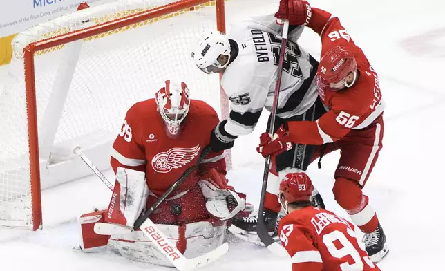 Detroit Red Wings goaltender Cam Talbot (39) stops a Los Angeles Kings right wing Quinton Byfield (55) shot as Erik Gustafsson (56) defends in the second period of an NHL hockey game Monday, Jan. 27, 2025, in Detroit. (AP Photo/Paul Sancya)