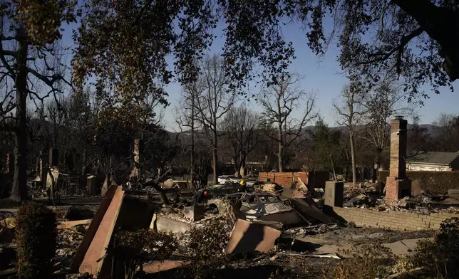 FILE - Search and rescue crew inspect homes destroyed by the Eaton Fire in in Altadena, Calif., is seen Wednesday, Jan 15, 2025. (AP Photo/John Locher, File)