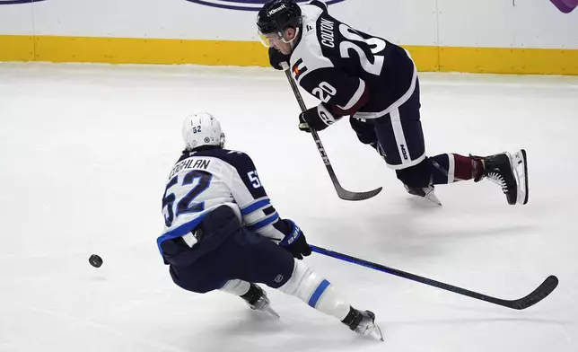 Colorado Avalanche center Ross Colton, right, pursues the puck with Winnipeg Jets defenseman Dylan Coghlan in the first period of an NHL hockey game Tuesday, Dec. 31, 2024, in Denver. (AP Photo/David Zalubowski)