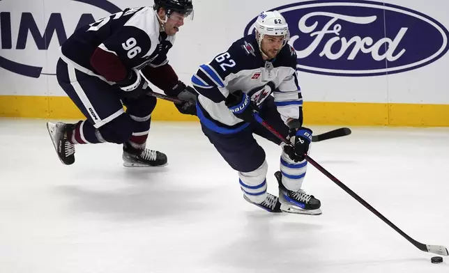 Winnipeg Jets right wing Nino Niederreiter, right, drives past Colorado Avalanche right wing Mikko Rantanen in the third period of an NHL hockey game Tuesday, Dec. 31, 2024, in Denver. (AP Photo/David Zalubowski)