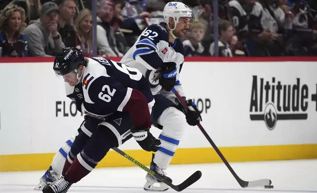 Winnipeg Jets right wing Nino Niederreiter, right, collects the puck as Colorado Avalanche left wing Artturi Lehkonen, left, defends in the second period of an NHL hockey game Tuesday, Dec. 31, 2024, in Denver. (AP Photo/David Zalubowski)