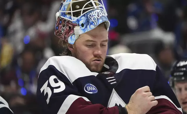 Colorado Avalanche goaltender Mackenzie Blackwood adjusts his jersey during a timeout in the second period of an NHL hockey game against the Winnipeg Jets, Tuesday, Dec. 31, 2024, in Denver. (AP Photo/David Zalubowski)