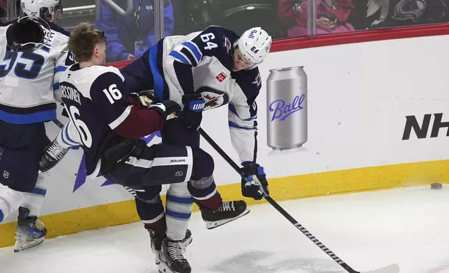 Winnipeg Jets defenseman Logan Stanley, right, checks Colorado Avalanche center Juuso Parssinen in the first period of an NHL hockey game Tuesday, Dec. 31, 2024, in Denver. (AP Photo/David Zalubowski)