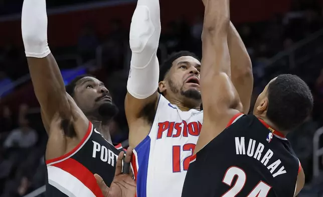 Detroit Pistons forward Tobias Harris (12) takes a shot against Portland Trail Blazers center Deandre Ayton, left, and forward Kris Murray (24) during the first half of an NBA basketball game Monday, Jan. 6, 2025, in Detroit. (AP Photo/Duane Burleson)