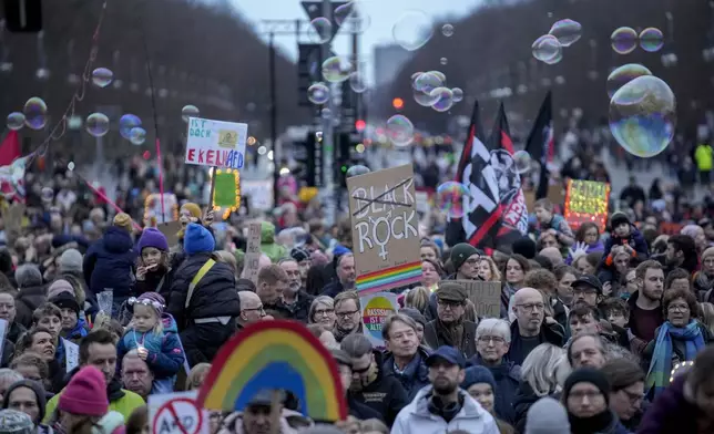 People gather to protest against the far-right Alternative for Germany, or AfD party, and right-wing extremism in front of the Brandenburg Gate in Berlin, Germany, Saturday, Jan. 25, 2025. (AP Photo/Ebrahim Noroozi)