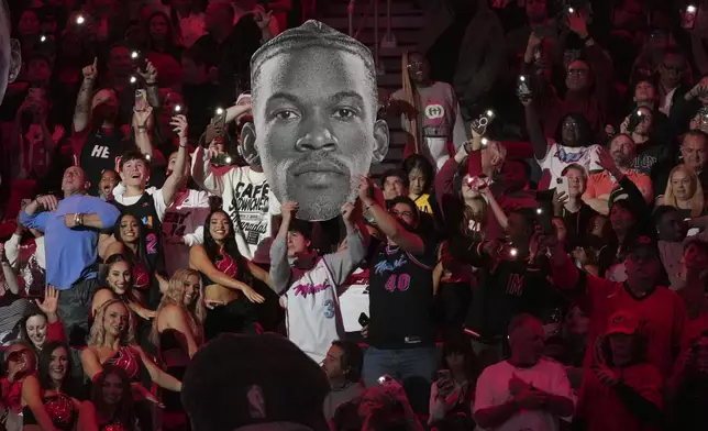 Fans hold up a portrait of Miami Heat forward Jimmy Butler during the second half of an NBA basketball game against the Indiana Pacers Thursday, Jan. 2, 2025, in Miami. (AP Photo/Lynne Sladky)