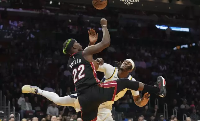 Miami Heat forward Jimmy Butler (22) goes to the basket as Indiana Pacers center Myles Turner, right, defends during the first half of an NBA basketball game Thursday, Jan. 2, 2025, in Miami. (AP Photo/Lynne Sladky)