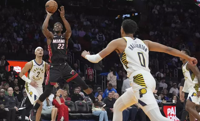 Miami Heat forward Jimmy Butler (22) shoots over Indiana Pacers guard Andrew Nembhard (2) and guard Tyrese Haliburton (0) during the first half of an NBA basketball game Thursday, Jan. 2, 2025, in Miami. (AP Photo/Lynne Sladky)