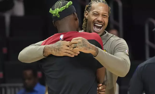 Indiana Pacers forward James Johnson, right, talks with Miami Heat forward Jimmy Butler before an NBA basketball game Thursday, Jan. 2, 2025, in Miami. (AP Photo/Lynne Sladky)