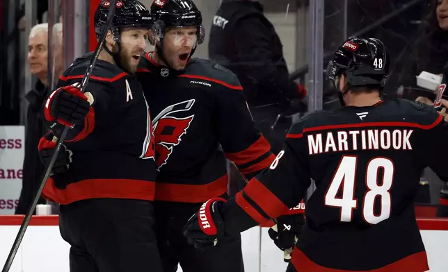 Carolina Hurricanes' Jordan Staal, center, celebrates after his goal with teammates Jaccob Slavin, left, and Jordan Martinook (48) during the second period of an NHL hockey game against the Toronto Maple Leafs in Raleigh, N.C., Thursday, Jan. 9, 2025. (AP Photo/Karl DeBlaker)