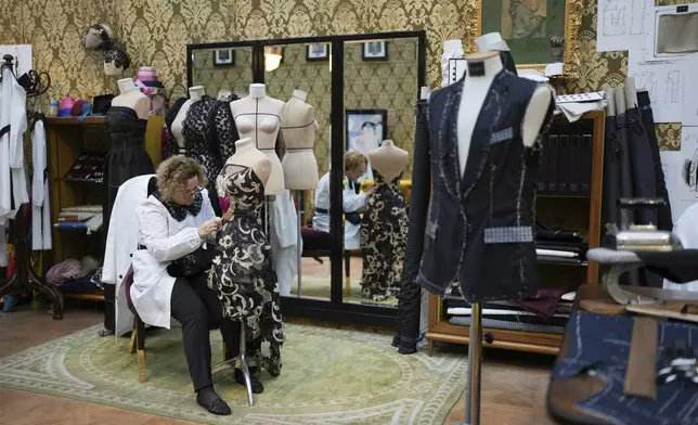 A seamstress works on a dress during the exhibition "From the Heart to the Hands: Dolce&amp;Gabbana" at the Grand Palais, in Paris, Thursday, Jan. 9, 2025. (AP Photo/Thibault Camus)