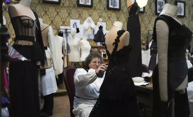 A seamstress works on a dress during the exhibition "From the Heart to the Hands: Dolce&amp;Gabbana" at the Grand Palais, in Paris, Thursday, Jan. 9, 2025. (AP Photo/Thibault Camus)