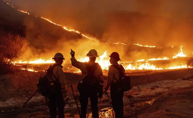 Fire crews battle the Kenneth Fire in the West Hills section of Los Angeles, Thursday, Jan. 9, 2025. (AP Photo/Ethan Swope)