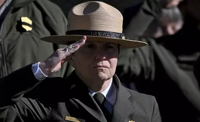 National Historical Park Superintendent Jill Stuckey and other NPS employees, based out of Sumter County, Ga., salute the hearse carrying former President Jimmy Carter as the motorcade stops in front of the Boyhood Farm, where Carter grew up, Saturday, Jan. 4, 2025, in Plains, Ga. (Hyosub Shin/Atlanta Journal-Constitution via AP, Pool)