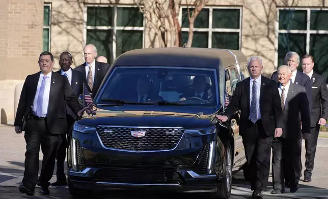 Former and current U.S. Secret Service agents assigned to the Carter detail, walk with the hearse carrying the flag-draped casket of former President Jimmy Carter, at Phoebe Sumter Medical Center in Americus, Ga., Saturday, Jan. 4, 2025. Carter died Dec. 29 at the age of 100. (AP Photo/Alex Brandon, Pool)