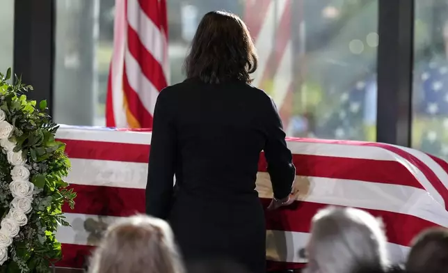 Paige Alexander, CEO of The Carter Center, touches the casket, as Amy Carter and her husband John Joseph "Jay" Kelly, foreground, watch, during a service for former President Jimmy Carter at the Jimmy Carter Presidential Library and Museum in Atlanta, Saturday, Jan. 4, 2025. Carter died Dec. 29 at the age of 100. (AP Photo/Alex Brandon, Pool)