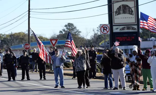 People line the road before the hearse with the casket of former President Jimmy Carter departs Phoebe Sumter Medical Center in Americus, Ga., Saturday, Jan. 4, 2025. Carter died Dec. 29 at the age of 100. (AP Photo/Alex Brandon, Pool)