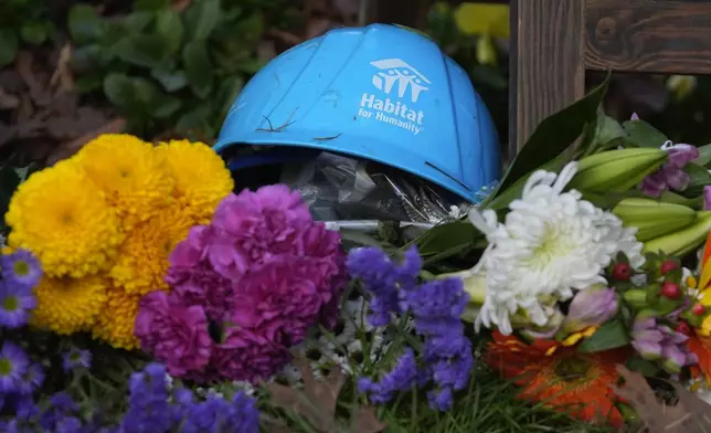 A Habitat for Humanity hard hat is among the items left in tribute to former President Jimmy Carter at the entrance to the Jimmy Carter Presidential Center Tuesday, Dec. 31, 2024, in Atlanta. Carter died Sunday at he age of 100. (AP Photo/John Bazemore )