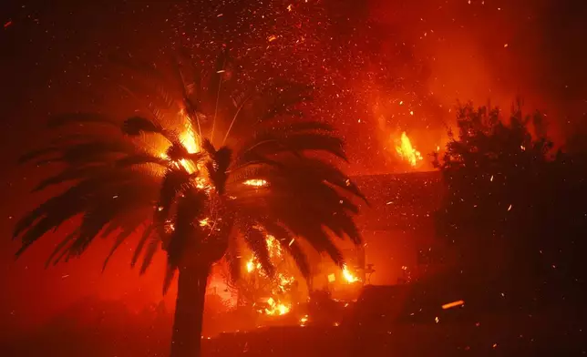 The Palisades Fire burns trees and homes in the Pacific Palisades neighborhood of Los Angeles, Tuesday, Jan. 7, 2025. (AP Photo/Etienne Laurent)