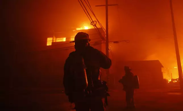 Firefighters battle the Palisades Fire in the Pacific Palisades neighborhood of Los Angeles, Tuesday, Jan. 7, 2025. (AP Photo/Etienne Laurent)