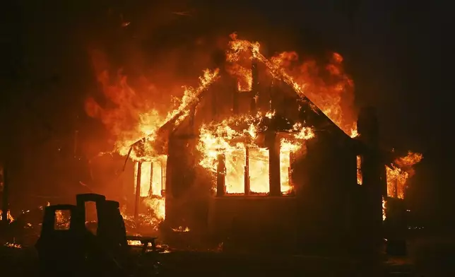 A structure burns as the Eaton Fire sweeps through Wednesday, Jan. 8, 2025 in Altadena, Calif. (AP Photo/Nic Coury)