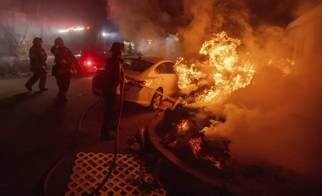 Firefighters battle the Eaton Fire Tuesday, Jan. 7, 2025 in Altadena, Calif. (AP Photo/Ethan Swope)