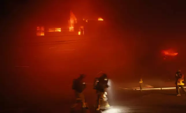 Firefighters battle the Palisades Fire in the Pacific Palisades neighborhood of Los Angeles, Tuesday, Jan. 7, 2025. (AP Photo/Etienne Laurent)