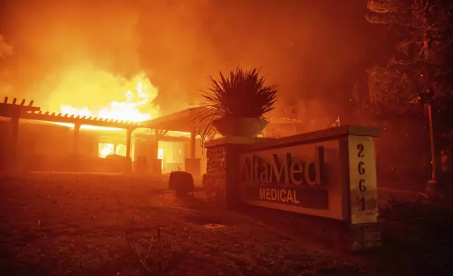 The Eaton Fire burns the AltaMed Medical building Wednesday, Jan. 8, 2025 in Altadena, Calif. (AP Photo/Ethan Swope)