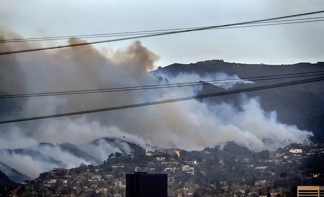 Spot fires along a hillside burn the Brentwood section of Los Angeles on Wednesday, Jan. 8, 2025. (AP Photo/Richard Vogel)