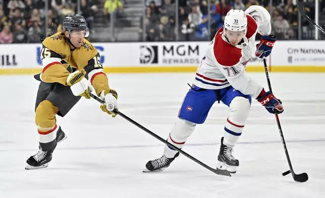 Vegas Golden Knights defenseman Noah Hanifin (15) and Montreal Canadiens center Jake Evans (71) battle for the puck during the first period of an NHL hockey game Tuesday, Dec. 31, 2024, in Las Vegas. (AP Photo/David Becker)