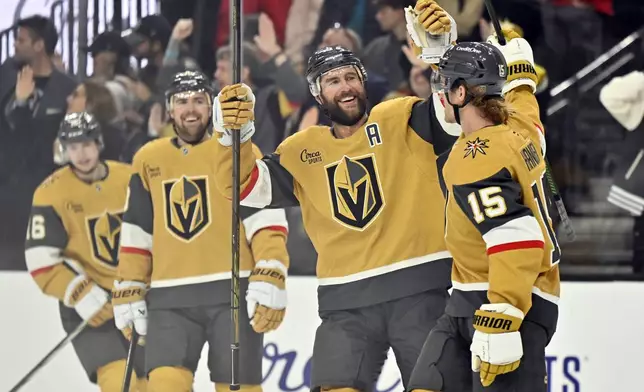 Vegas Golden Knights defenseman Alex Pietrangelo, second right, congratulates Noah Hanifin (15) after scoring against the Montreal Canadiens during the first period of an NHL hockey game Tuesday, Dec. 31, 2024, in Las Vegas. (AP Photo/David Becker)