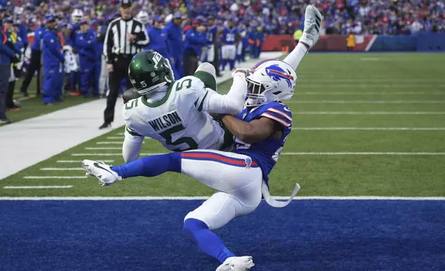 New York Jets wide receiver Garrett Wilson (5) makes a catch for a touchdown over Buffalo Bills cornerback Brandon Codrington (29) during the second half of an NFL football game, Sunday, Dec. 29, 2024, in Orchard Park, N.Y. (AP Photo/Gene J. Puskar)