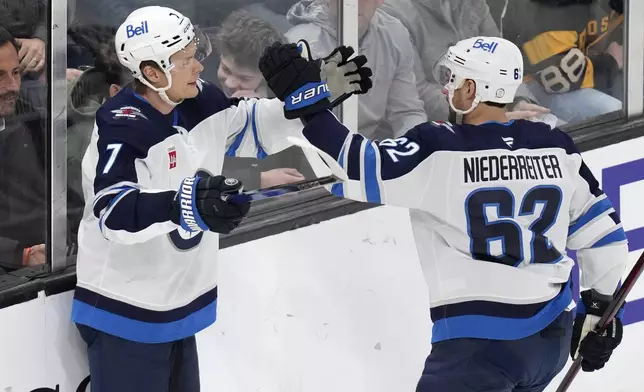 Winnipeg Jets center Vladislav Namestnikov (7) is congratulated by Nino Niederreiter (62) after his goal against Boston Bruins goaltender Joonas Korpisalo during the first period of an NHL hockey game, Thursday, Jan. 30, 2025, in Boston. (AP Photo/Charles Krupa)