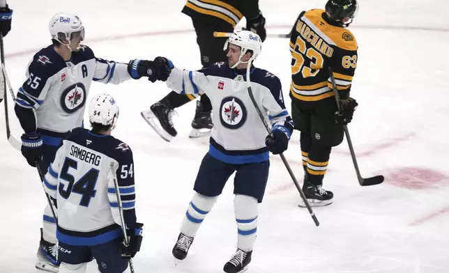 Winnipeg Jets center Mark Scheifele (55) is congratulated after his goal against the Boston Bruins during the first period of an NHL hockey game, Thursday, Jan. 30, 2025, in Boston. (AP Photo/Charles Krupa)
