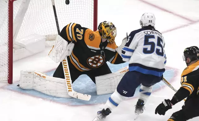 Winnipeg Jets center Mark Scheifele (55) shoots the puck past Boston Bruins goaltender Joonas Korpisalo (70) for a goal during the third period of an NHL hockey game, Thursday, Jan. 30, 2025, in Boston. (AP Photo/Charles Krupa)
