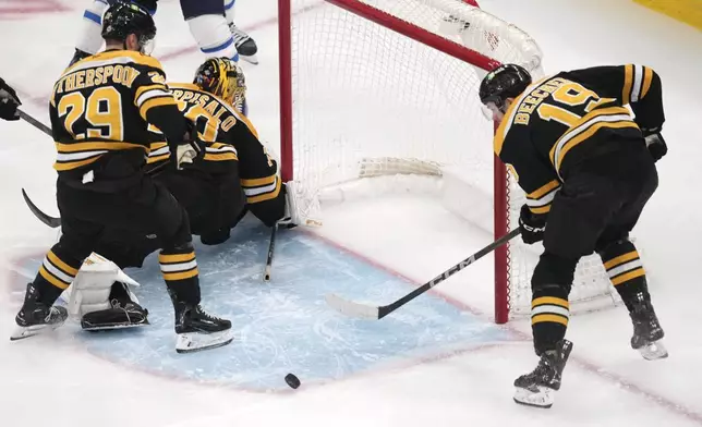 Boston Bruins center John Beecher (19) clears the puck away from the crease during the second period of an NHL hockey game against the Winnipeg Jets, Thursday, Jan. 30, 2025, in Boston. (AP Photo/Charles Krupa)
