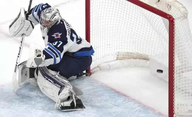 Winnipeg Jets goaltender Connor Hellebuyck fails to make the save on a goal by Boston Bruins left wing Brad Marchand during the first period of an NHL hockey game, Thursday, Jan. 30, 2025, in Boston. (AP Photo/Charles Krupa)