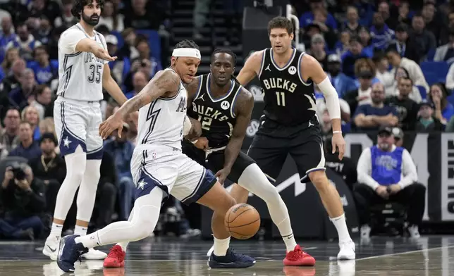 Orlando Magic forward Paolo Banchero, center, goes after a loose ball in front of Milwaukee Bucks center Brook Lopez (11) and forward Taurean Prince (12) during the first half of an NBA basketball game, Friday, Jan. 10, 2025, in Orlando, Fla. (AP Photo/John Raoux)