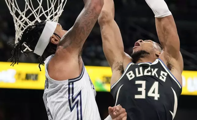 Milwaukee Bucks forward Giannis Antetokounmpo (34) makes a shot over Orlando Magic forward Paolo Banchero, left, during the first half of an NBA basketball game, Friday, Jan. 10, 2025, in Orlando, Fla. (AP Photo/John Raoux)
